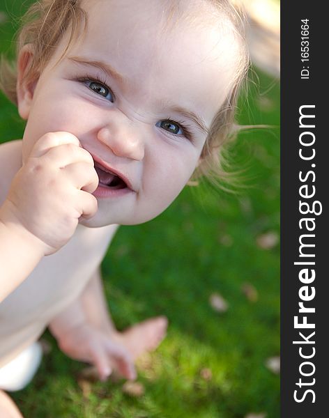 Pretty smilling little girl sitting outdoors. Pretty smilling little girl sitting outdoors