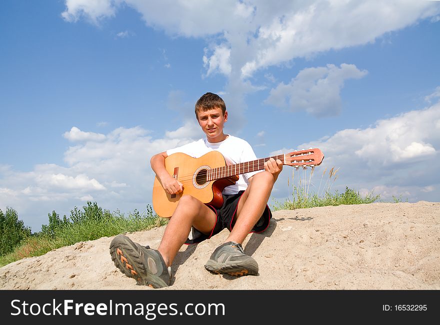 A teenager plays on a guitar