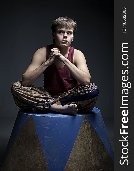 Circus actor posing on curbsone in studio