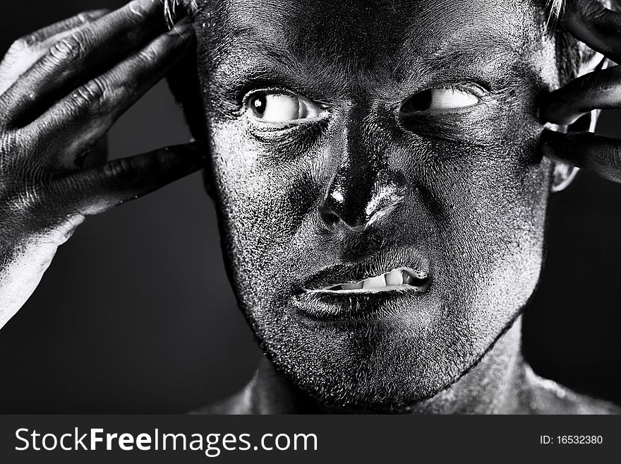 Portrait of expressive man painted with black color. Body painting project. Portrait of expressive man painted with black color. Body painting project.