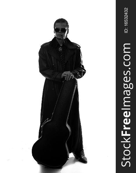 Man in the dark coat with guitar case. Man in the dark coat with guitar case