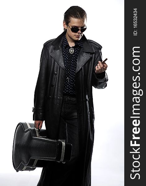 Man in the dark coat with guitar case. Man in the dark coat with guitar case