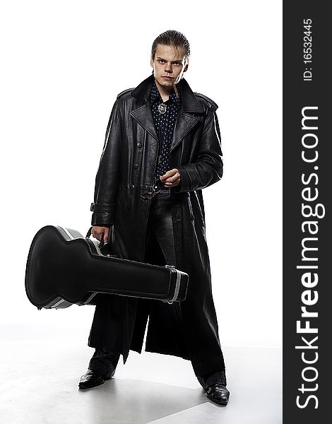 Man in the dark coat with guitar case. Man in the dark coat with guitar case