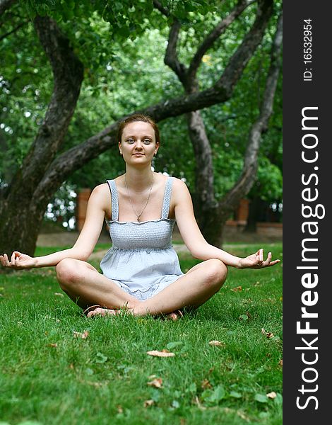 Girl In the lotus posture in park