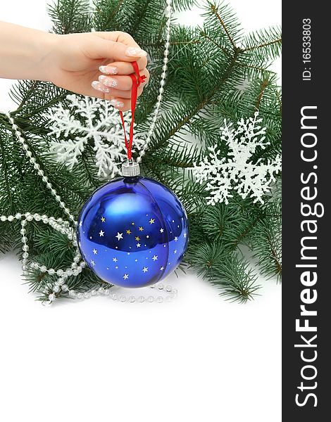 Female hand holding a Christmas ball on natural christmas tree. Female hand holding a Christmas ball on natural christmas tree