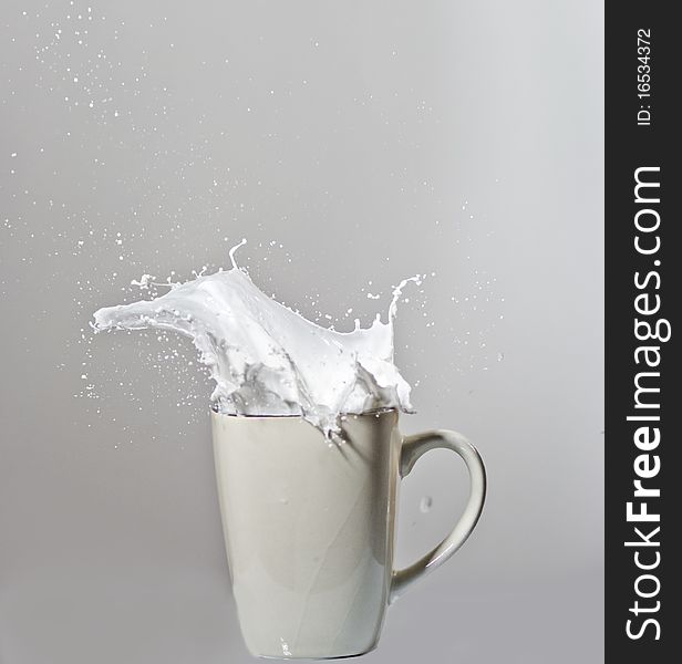 Exploding glass of milk with droplets in the air