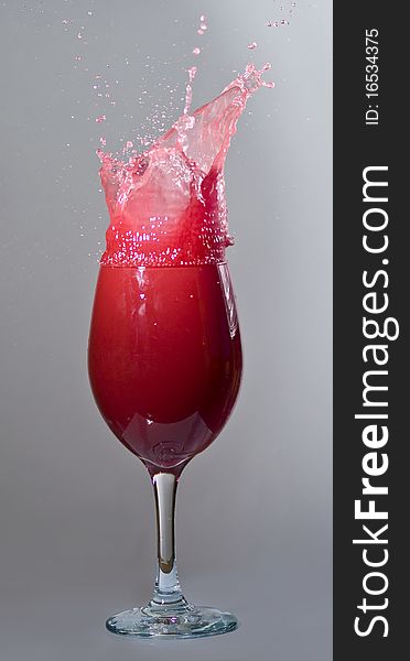 Exploding red drink on gray background. Exploding red drink on gray background