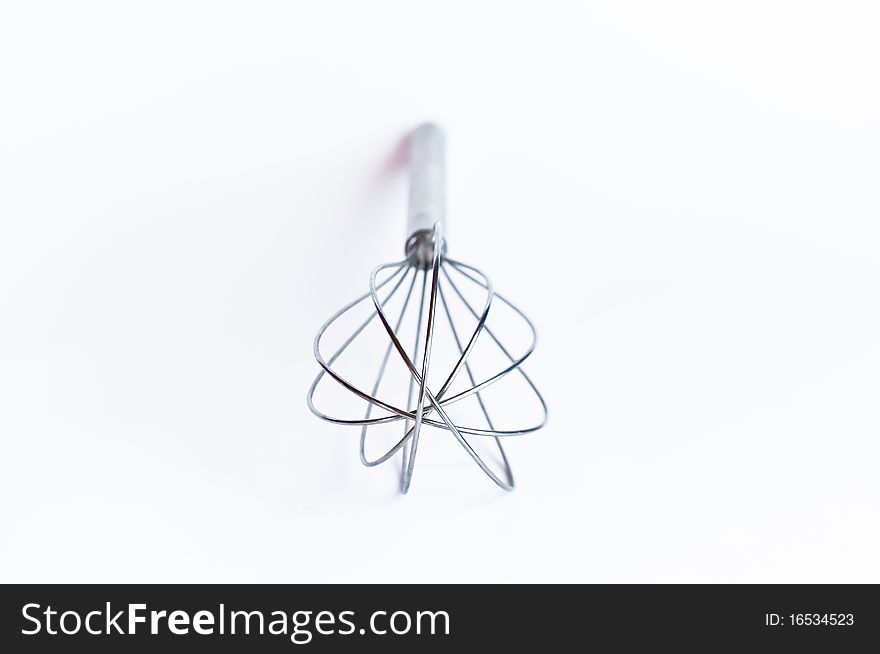 Shiny metal whisk on the white background. Shiny metal whisk on the white background