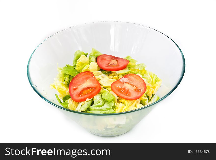 A bowl of fresh green salad decorated with tomato. A bowl of fresh green salad decorated with tomato