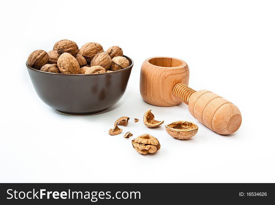 Nut cracker with walnuts in brown bowl and cracked nut. Nut cracker with walnuts in brown bowl and cracked nut