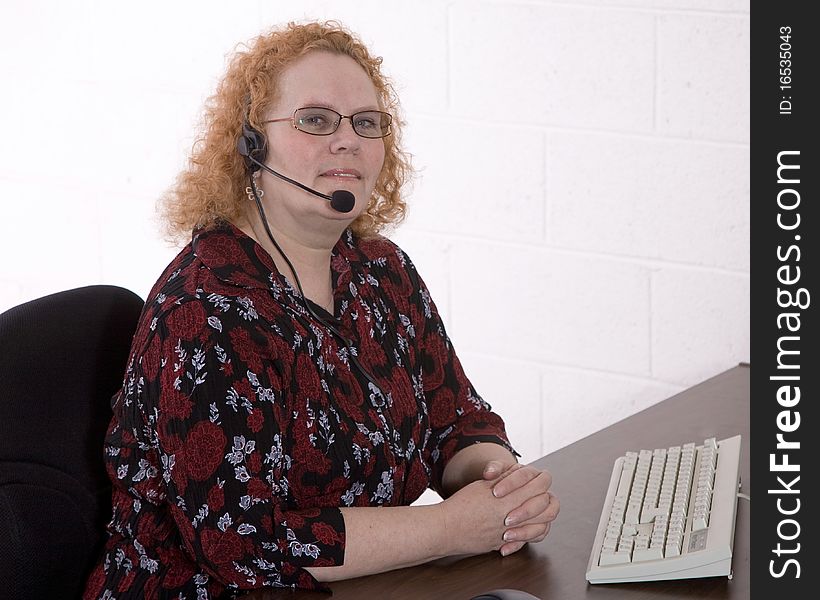 Productive middle aged woman working in a call center. Productive middle aged woman working in a call center