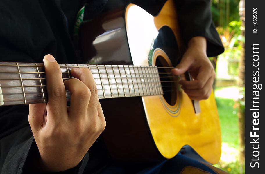 Man playing folk guitar with left hand