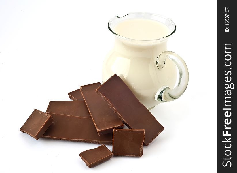 Milk chocolate and milk jug on a white background. Milk chocolate and milk jug on a white background