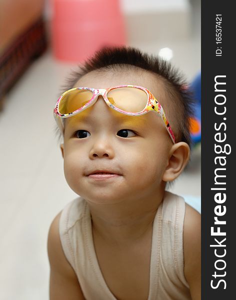 It is a cute chinese baby with glasses in home. It is a cute chinese baby with glasses in home.
