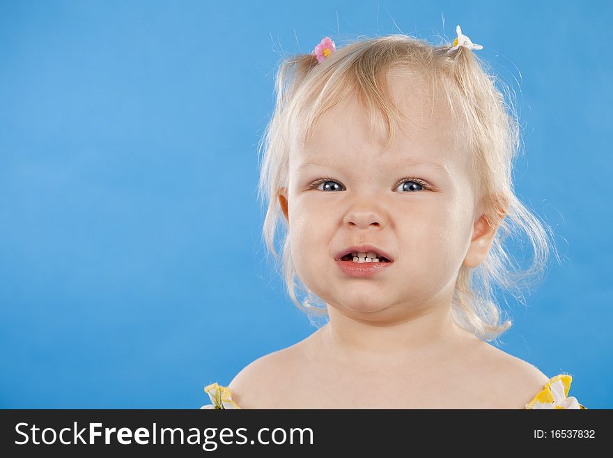 Beautiful little girl the blonde on a blue background. Beautiful little girl the blonde on a blue background
