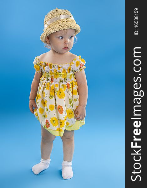 Serious little girl in a hat on a blue background. Serious little girl in a hat on a blue background