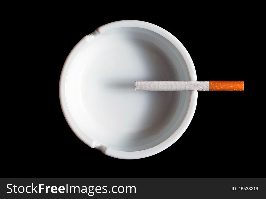 Cigarette ashtray in white on a black background. Cigarette ashtray in white on a black background