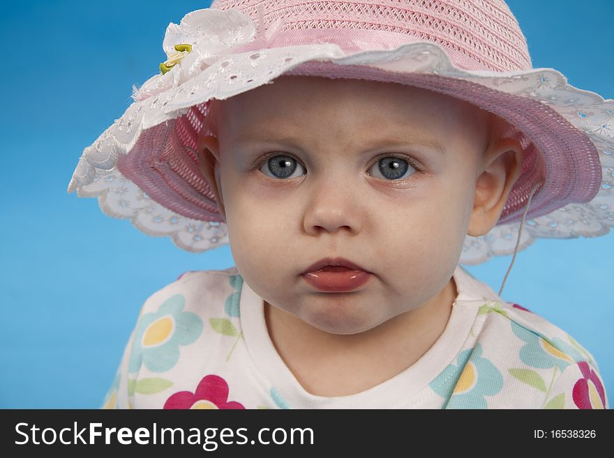 Child in the big hat on a blue background. Child in the big hat on a blue background