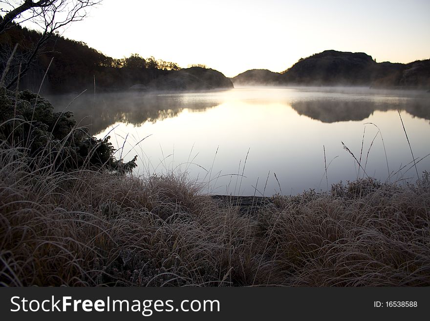 Frozen mist covering a mountain lake an early morning. Frozen mist covering a mountain lake an early morning