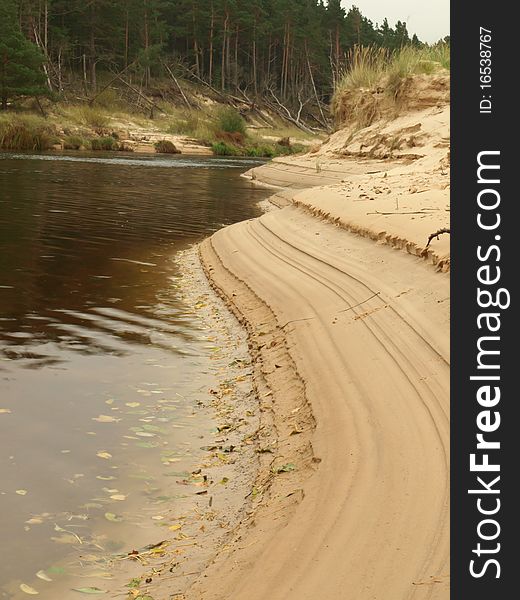 River coast with stream imprint in the sand