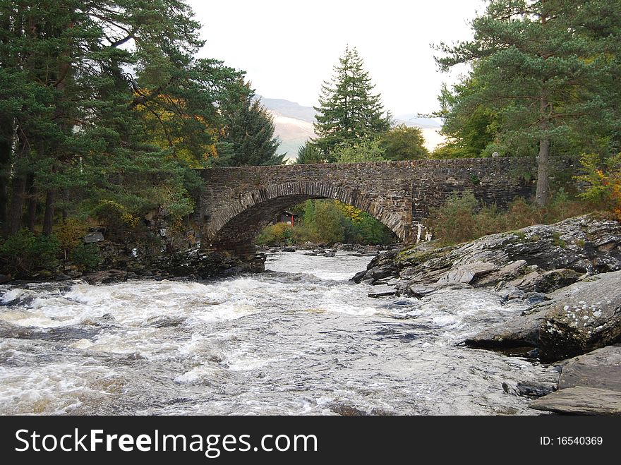 A view of the river dochart as it approaches an old stone bridge. A view of the river dochart as it approaches an old stone bridge