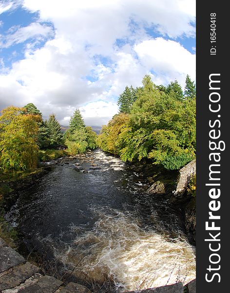 A view from the old stone bridge of the river dochart as it flows away from the falls. A view from the old stone bridge of the river dochart as it flows away from the falls