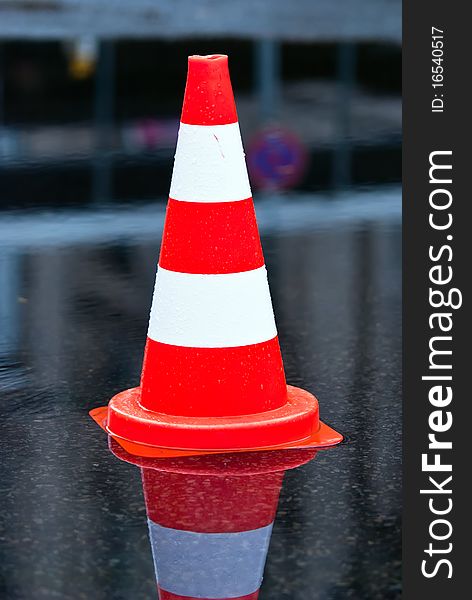 Warning cone in a puddle at the street. Warning cone in a puddle at the street