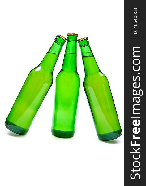 Three cold beers in green bottles isolated on white. Soft shadow. Three cold beers in green bottles isolated on white. Soft shadow