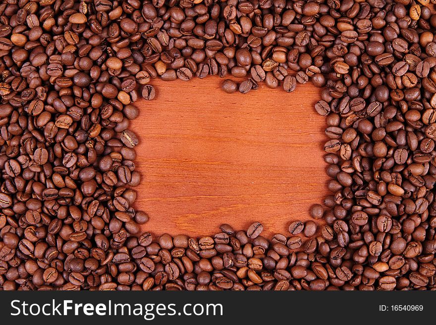 Coffee beans with wooden background in the middle with space for text