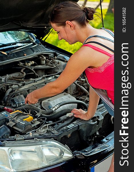 Young woman repairing her car. Young woman repairing her car