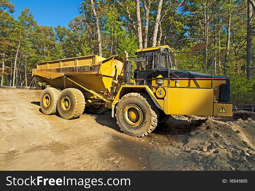 Big, yellow earth moving truck on a job construction site