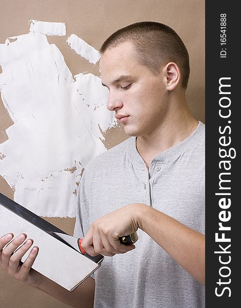 Caucasian man plastering a brown wall with white plaster. Caucasian man plastering a brown wall with white plaster.