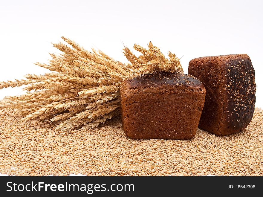 Bread with wheat and ears on white