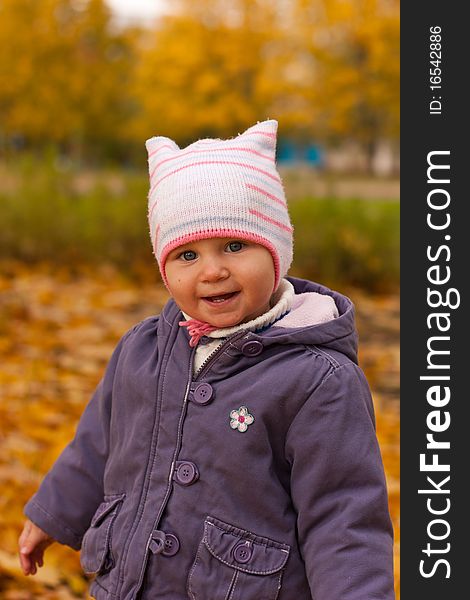 Baby girl in cute hat close up against autumn nature. Baby girl in cute hat close up against autumn nature