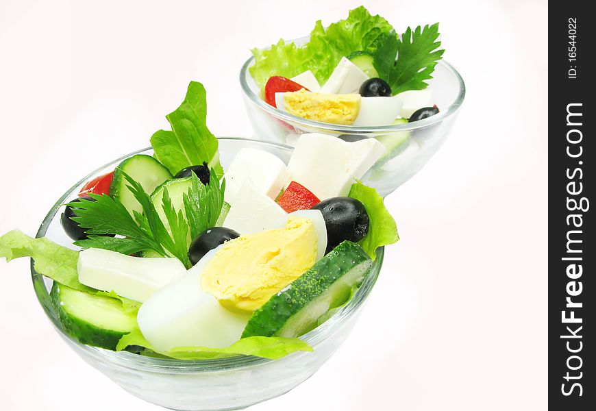 Greek salad with cheese egg olive and tomato in two glass bowls. Greek salad with cheese egg olive and tomato in two glass bowls