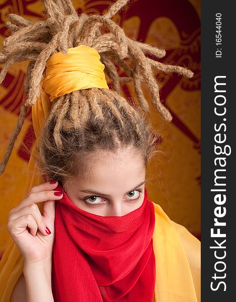 Young woman with African dreadlocks in yellow and red cloth covered the face. Young woman with African dreadlocks in yellow and red cloth covered the face
