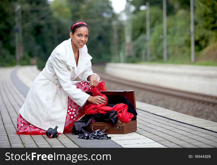 A young woman rummages in her suitcase. A young woman rummages in her suitcase