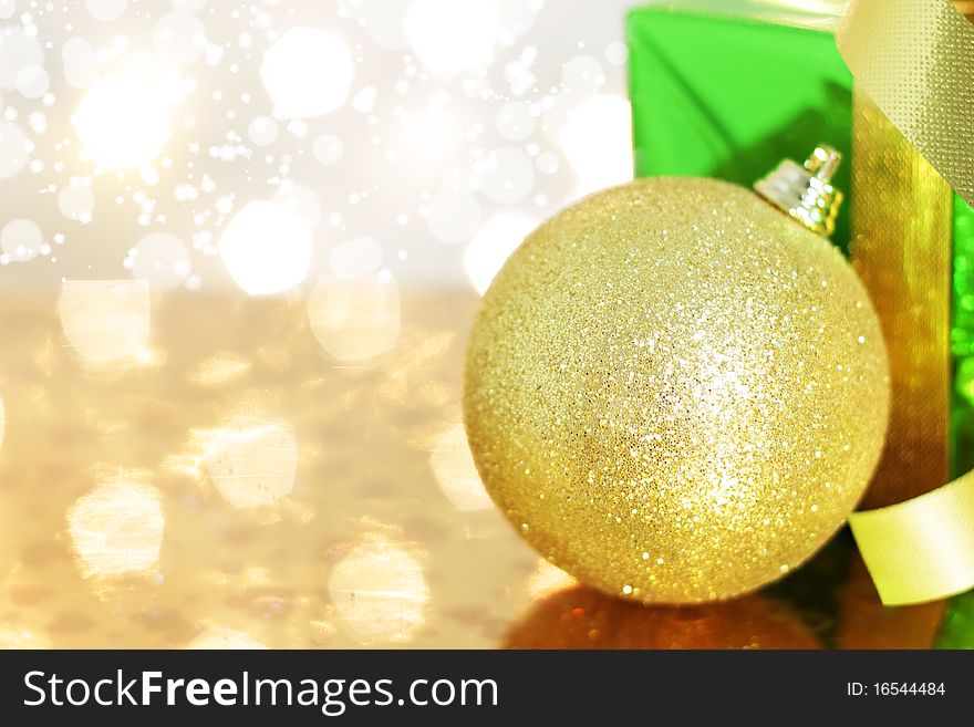 Gift box and Christmas ball on a background of lights