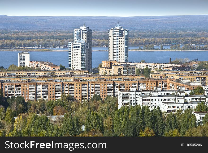 Urban landscape. Typical residential area on the riverbank. The view from the heights in the background high-rise apartment building. Russia.