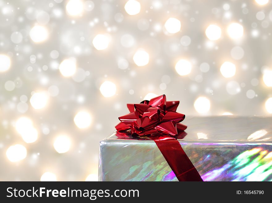 Red bow on the box against the backdrop of lights