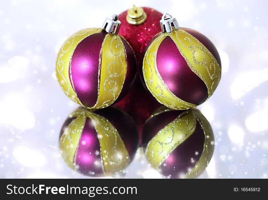 Three red Christmas balls on a background of lights
