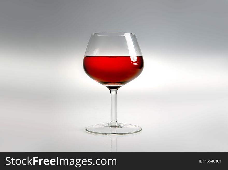 Glass with red wine on neutral background