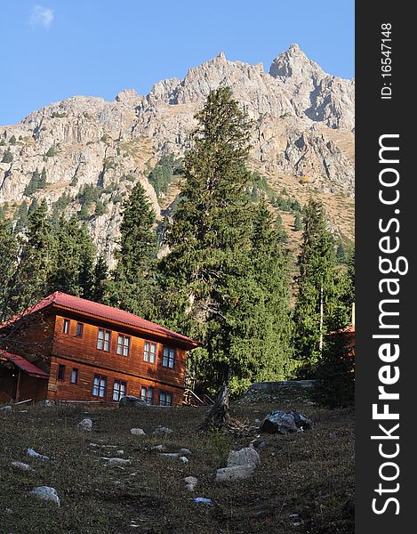 Simple living: Wooden house close to Mountain top in tien shan mountains near almaty kazakhstan on a sunny fall day. Simple living: Wooden house close to Mountain top in tien shan mountains near almaty kazakhstan on a sunny fall day