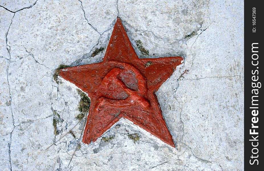 Red soviet star on cracked wall of a monument