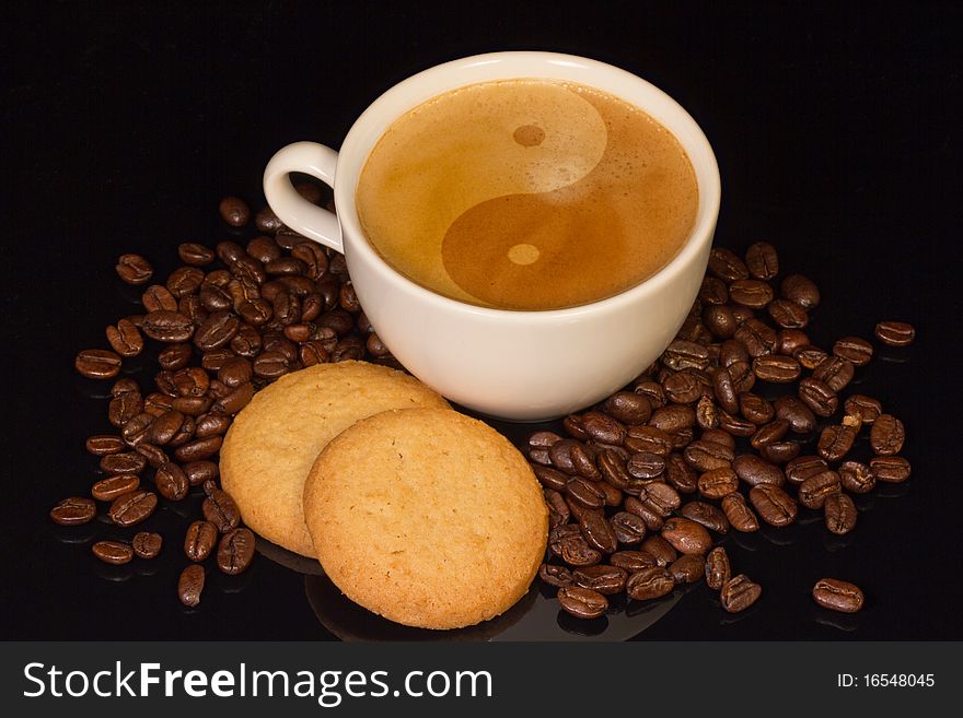 Cup of coffee with ying-yang symbol, biscuits and coffee beans. Cup of coffee with ying-yang symbol, biscuits and coffee beans