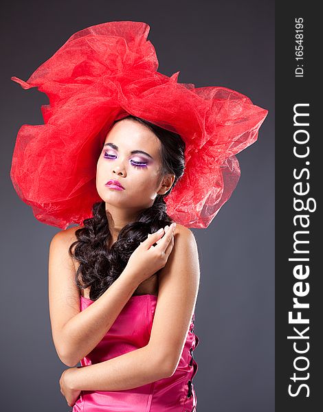 beautiful brunette woman in red tulle hat