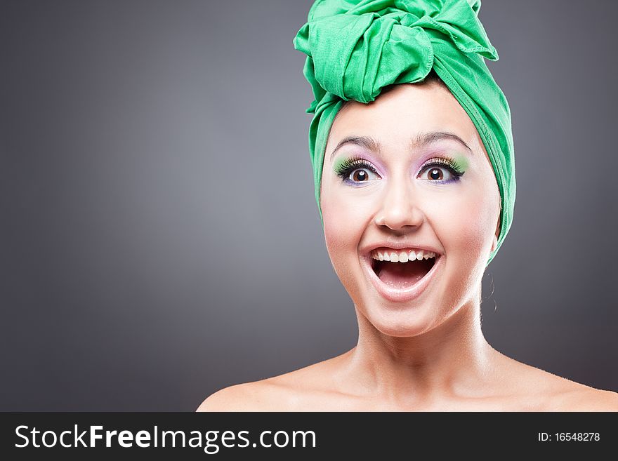 Happy excited woman with pink-green makeup in green hat