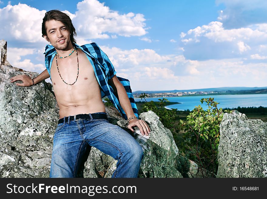 Handsome young man hippie posing over picturesque landscape. Handsome young man hippie posing over picturesque landscape.