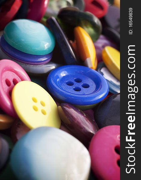 Group of multi-coloured vintage buttons. Focus on the blue one in the middle.