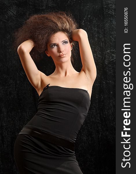 Portrait of the beautiful young woman with a magnificent hairdress on a black background.